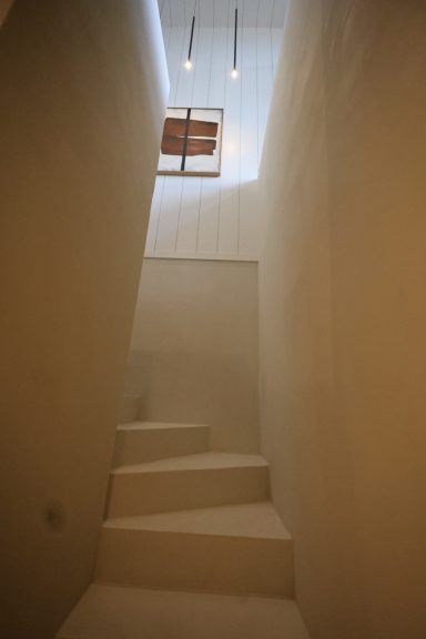 Escalier blanc minimaliste éclairé par la lumière naturelle.