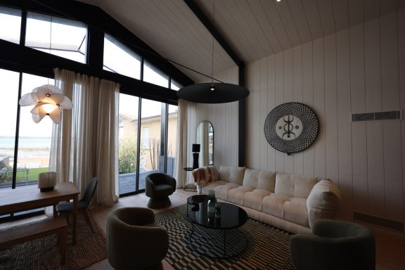 Vue d’ensemble du salon sous la charpente noire de la maison.