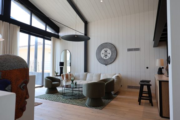 Salon lumineux sous une charpente noire dans une maison au Cap Ferret.