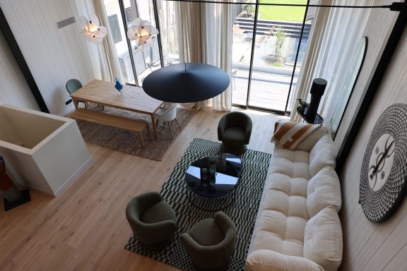 Vue plongeante sur le salon et la salle à manger baignés de lumière naturelle.