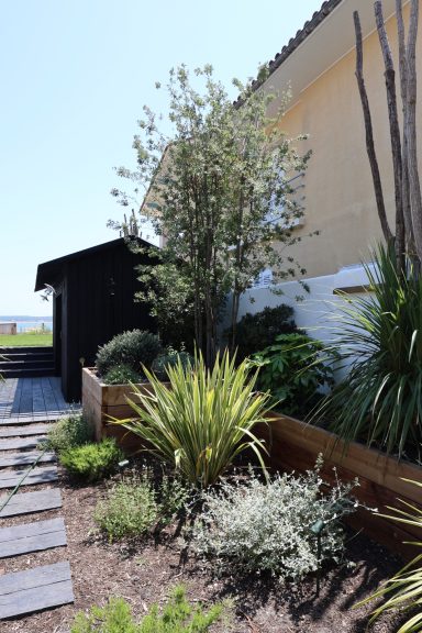Aménagement paysager composé de plantes locales et de terrasses en bois.