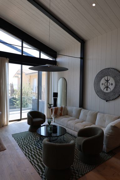 Salon ouvert sur la terrasse avec décoration murale graphique.