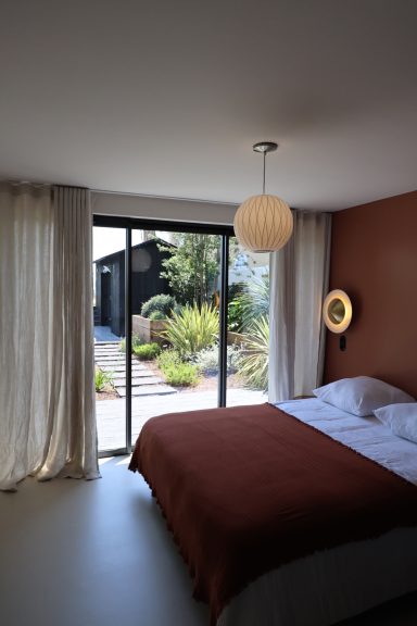 Chambre lumineuse ouverte sur la végétation extérieure au Cap Ferret.
