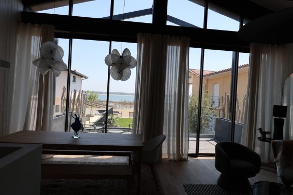 Salle à manger ouverte sur le jardin et le Bassin d’Arcachon.