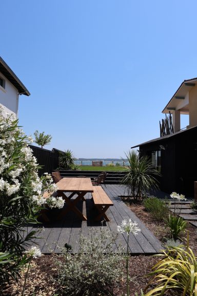 Coin repas extérieur entouré de végétation dans le jardin paysager.