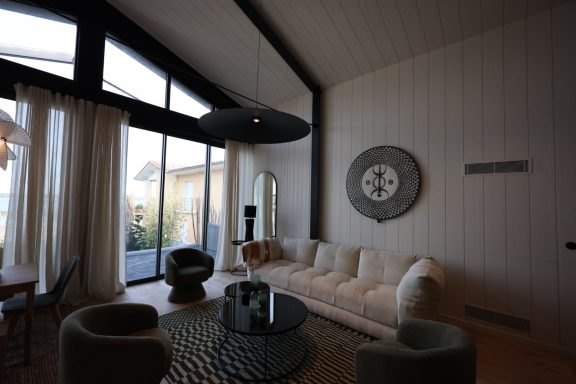 Salon contemporain sous une charpente noire au Cap Ferret.