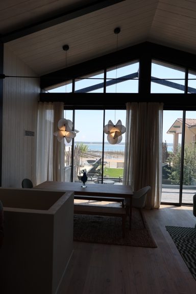 Salle à manger avec suspensions décoratives et vue sur le Bassin d’Arcachon.