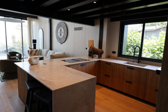 Cuisine sur mesure en bois avec grand plan de travail en pierre naturelle.